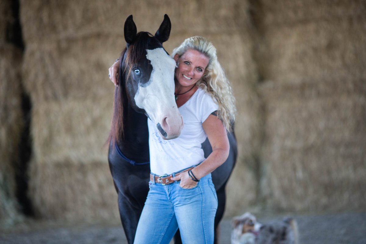 Caro mit ihrem Pferd Freddie und dem Hund vor den Heuballen