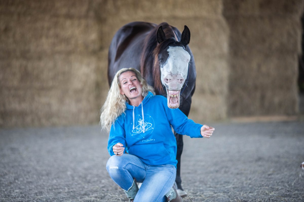 Caro hockt lachend vor ihrem Schecken